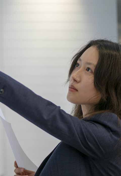 student pointing to data charts on wall